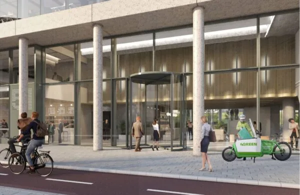 Moderne entree van een kantoorgebouw aan de Marten Meesweg met glazen gevel, draaiende deur en mensen op de stoep, waaronder een fietskoerier.